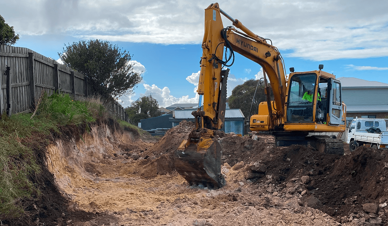 Excavator digging a trench on construction site.
