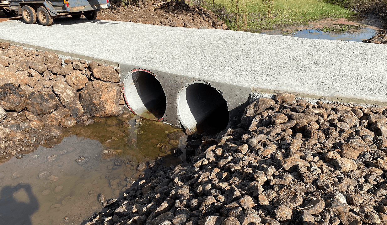 Concrete bridge over rocky water channel.