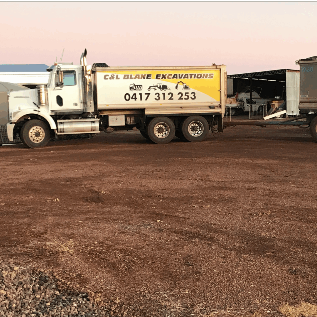 Excavation truck parked on gravel lot.